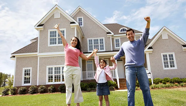 Happy family in front of their home